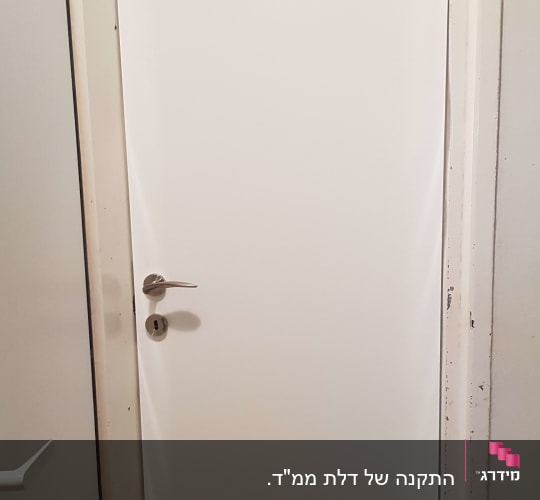דלת לבנה עם ידית מתכת כסופה